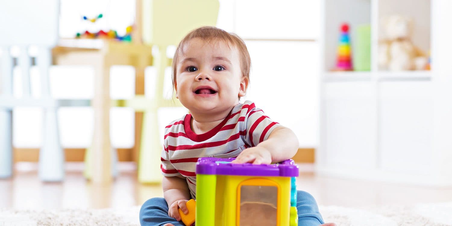 An infant playing with a toy in the classroom